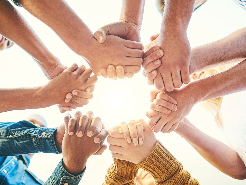 group of people holding hands, light shining brightly