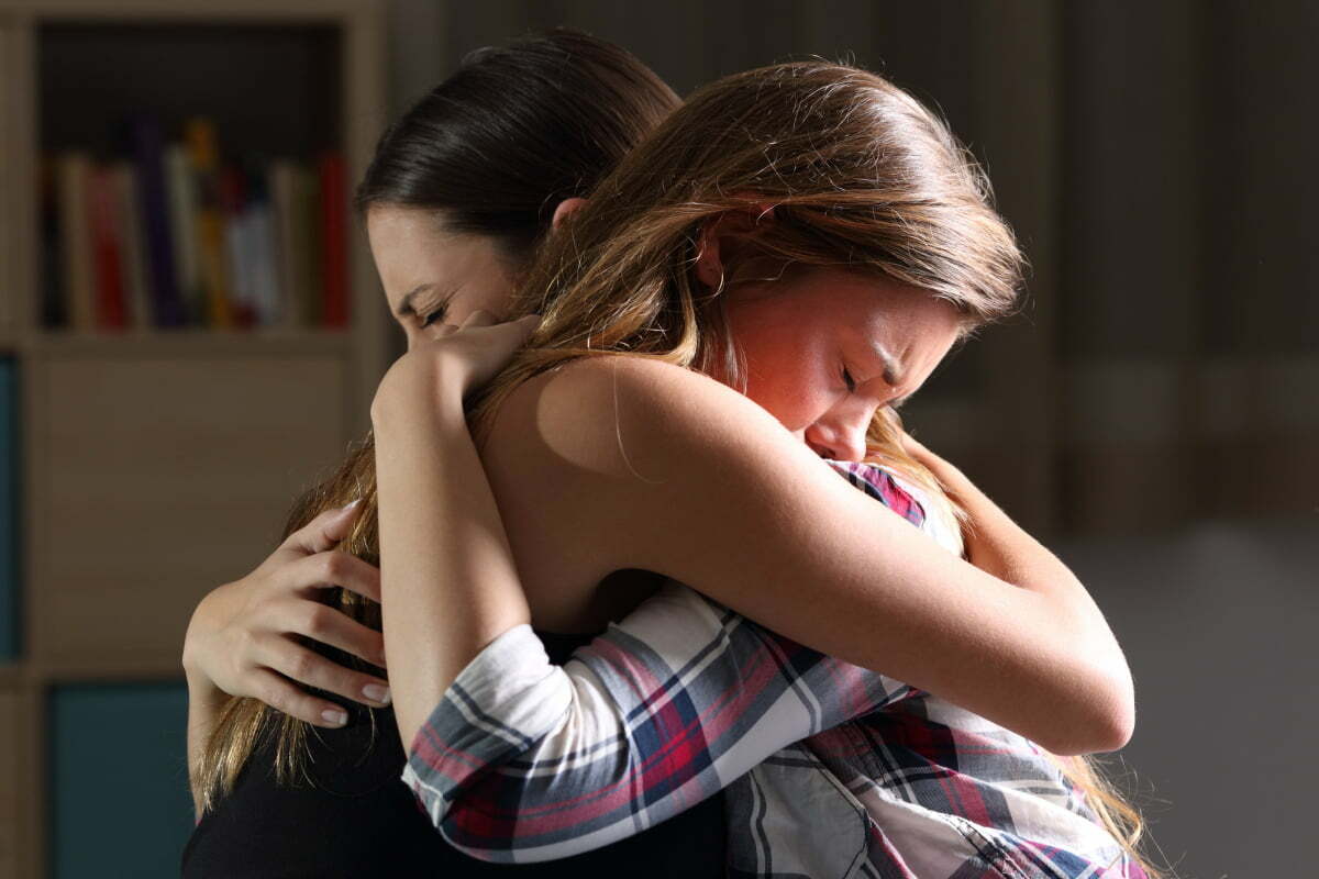 Two sad friends in a hug grieving together