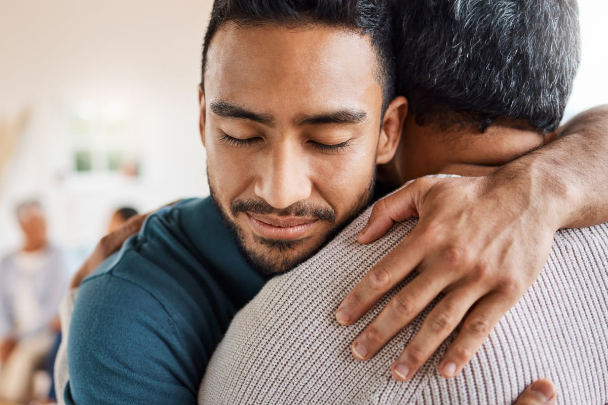Young man hugging father on Mother's Day
